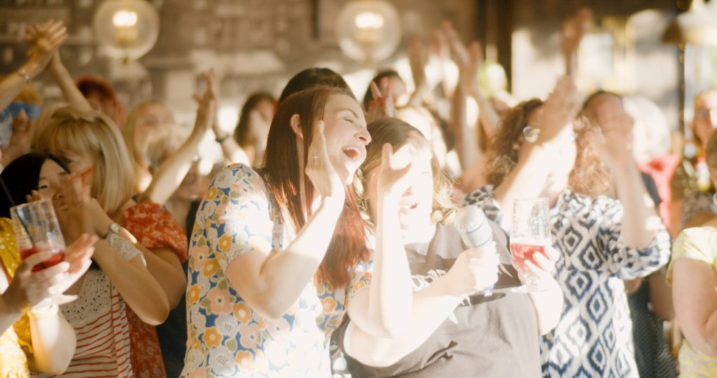 So Choir! Wakefield laughing and cheering in a sun-drenched bar