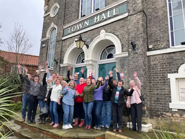 Selby Café Choir waving and cheering outside the front of Selby Town Hall